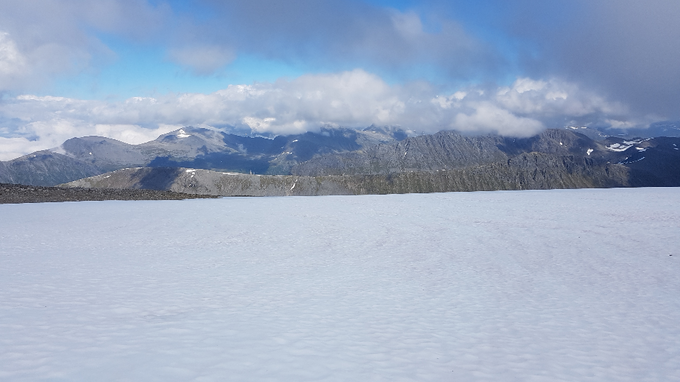 Dette bildet er tatt på Leirvasshornet i begynnelsen av juni og her kan en se konturen av Svartindane med snøskavler flekkvis langs hele ryggen. Bak der igjen ser en Emdalstindane